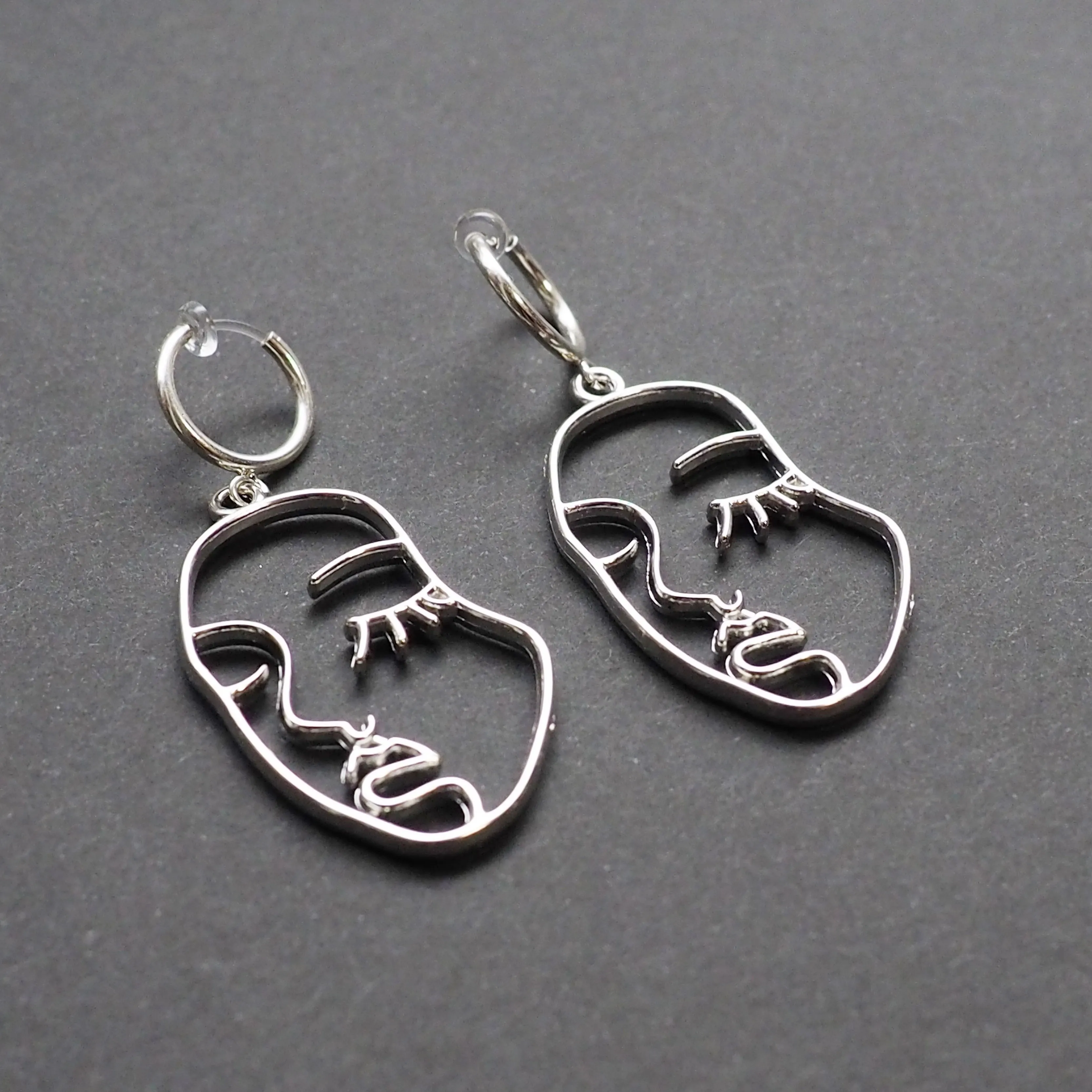 Silver human face clip on hoop earrings